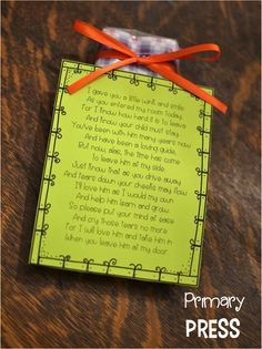 a piece of paper with an orange ribbon attached to it on top of a wooden table