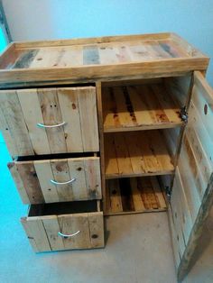 a wooden cabinet with three drawers and one door open on the bottom shelf is made out of pallet wood