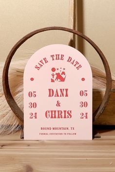 a save the date sign sitting on top of a wooden table next to a stuffed animal