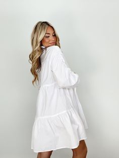 Indulge in luxury with our Collared Button Up Mini Dress. With its collared neckline, button closures, and ruched sleeves, this dress provides an elevated and trendy look. The mini and tiered design is perfect for any occasion, from brunch dates to elegant dinners. Its bright and versatile style is a must-have for your wardrobe, whether for a bridal event or a basic yet sophisticated look. Self 60% Cotton 40% Polyester Hand wash cold. Fitted Mini Length Tiered Dress For Daywear, Elegant Tiered Dress With Puff Sleeves, Elegant Tiered Dress With Gathered Sleeves, Chic Smocked Tiered Dresses, Spring Mini Shirt Dress With Ruffle Hem, Spring Mini Length Shirt Dress With Ruffle Hem, Chic Tiered Mini Dress For Daywear, Chic Puff Sleeve Tiered Dress For Daywear, Elegant Mini Dress With Gathered Sleeves For Day Out