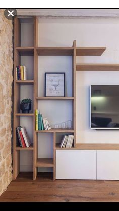 an entertainment center with bookshelves and a flat screen tv mounted on the wall