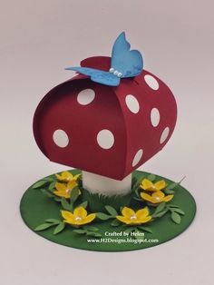 a red mushroom with white polka dots and a blue butterfly on it's top