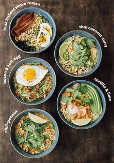 four bowls filled with different types of food on top of a wooden table next to an egg