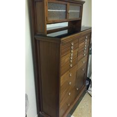 a wooden dresser with glass doors and drawers