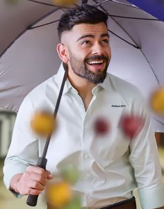 a man is holding an umbrella and smiling