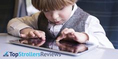 a little boy that is looking at something on a tablet screen and touching his hands