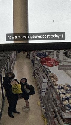 two people standing in the middle of a grocery store