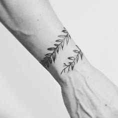 black and white photo of a person's arm with leaves on it