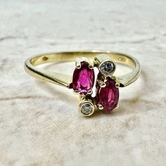 Fine vintage handcrafted 18 Karat yellow gold Toi-Et-Moi (bypass) ring set with 2 oval rubies weighing approximately 0.50 carat, and 2 round diamonds weighing approximately 0.05 carat, F-G VS. Stamped 750 with maker’s marks. This ring is a size 7.75 US / P 1/2 UK. > Resizing not included. This ring can be resized to fit most fingers. Please contact us for details. Resized rings are final sale. It weighs 2.3 grams. Birthstone: July/April. Condition: Very good. Minute scratches throughout metal. L Oval Multi-stone Ruby Ring In Yellow Gold, Oval Ruby Ring With Three Diamonds, Oval Three Stone Ruby Ring With Diamonds, Oval Multi-stone Ruby Ring For Anniversary, Gold Oval Ruby Ring With Diamond Accents, 14k Gold Multi-stone Oval Ruby Ring, Oval Multi-stone Ruby Ring In 14k Gold, Gold Oval Ruby Ring With Three Stones, Gold Ruby Ring With Three Stones, Oval Shaped