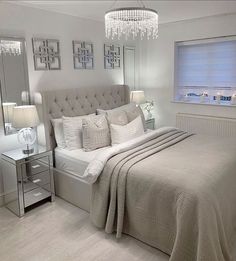 a bedroom with a large bed and chandelier