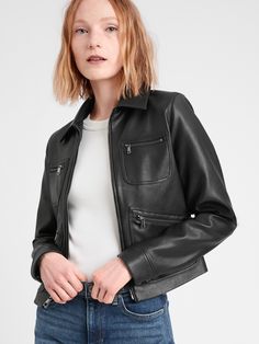 a woman is wearing a black leather jacket