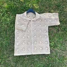 a crocheted jacket laying on the grass