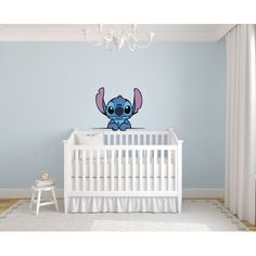 a baby's room with a crib and wall decal in the shape of an elephant