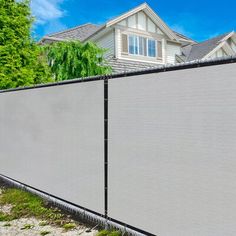 a house behind a fence with trees in the background