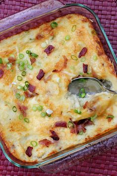 a casserole dish with meat, cheese and green onions in it on a purple place mat