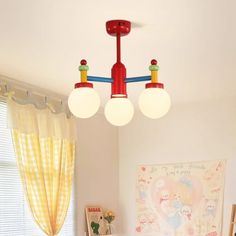 three lights are hanging from the ceiling above a bed in a child's bedroom