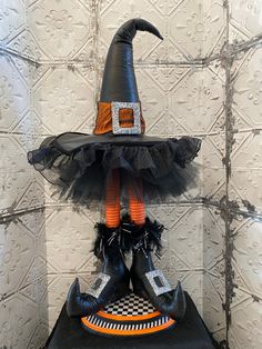 a black and orange witch hat sitting on top of a table next to two shoes