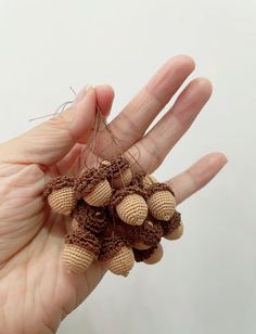 a hand holding some tiny crocheted objects in it's left palm area