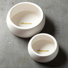 two white cups sitting on top of a table