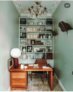 a room with a desk, bookshelf and other items on the shelves in it