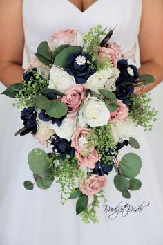 a bridal holding a bouquet of flowers and greenery