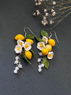 two lemons and white flowers are attached to silver earrings