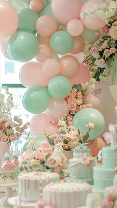 there are many balloons and cakes on the table in front of the cake is decorated with flowers