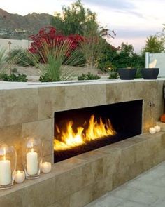 an outdoor fireplace with lit candles on it