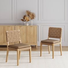 two chairs sitting next to each other in front of a dresser and sideboard with vases on it