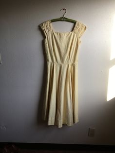 "1950s handmade sun dress yellow cotton w/very subtle leaf motif print sleeveless pullover wide pleated shoulder straps square neck/back fitted top w/breast darts side zipper pleated waist good vintage condition, light wear light rust color stains here and there measures, lying flat, shoulder-20\" bust-18 3/4\" (37 1/2\" total) waist-14\" (28\" total) top shoulder to waist-16 1/2\" total length-44\"" Summer Vintage A-line Pleated Dress, Spring Cotton Dress With Pleated Bodice, Fitted Cotton Vintage Dress For Spring, Spring Fitted Vintage Dress With Lining, Spring Vintage Fitted Cotton Dress, Spring Vintage Cotton Fitted Dress, Spring Vintage Fitted Lined Dress, Classic Vintage Dress With Fitted Bodice For Spring, Classic Fitted Cotton Vintage Dress