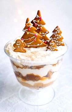 there is a dessert in the glass with gingerbread trees on top and white frosting