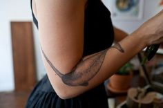 a woman with a bird tattoo on her arm