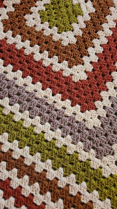 a crocheted blanket is shown with different colors and patterns on the bottom half