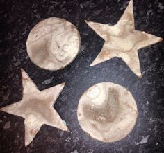 three star shaped cookies sitting on top of a table