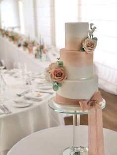 a three tiered wedding cake with pink flowers on top