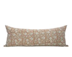 an orange and white floral pillow on a white background