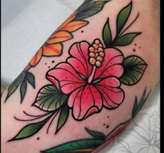 a flower tattoo on the arm with leaves and flowers around it's center piece