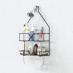 a bathroom shelf with bottles, soaps and lotions on it in front of a white tiled wall