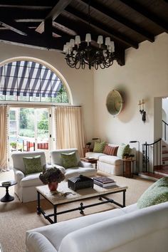 a living room filled with furniture and a chandelier