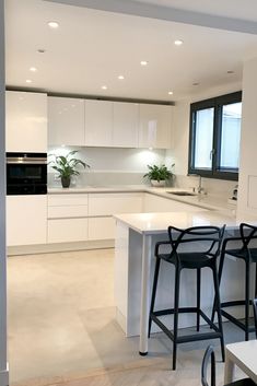 a kitchen with two bar stools next to an island