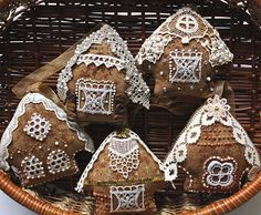 a wicker basket filled with brown and white gingerbread house cookies covered in crochet