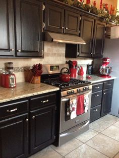 a kitchen with black cabinets and silver appliances