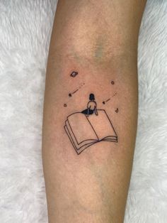 a person with a book tattoo on their leg