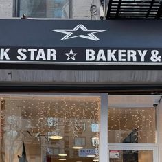 the front of a bakery with christmas lights on the windows and decorations hanging from the ceiling