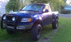 a blue pick up truck parked in the grass