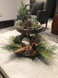 three tiered tray with pine cones and evergreen needles