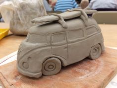 a clay car sitting on top of a wooden table