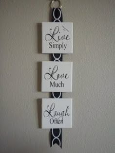 three signs are hanging on the wall above a door handle that says live simply love much laugh often