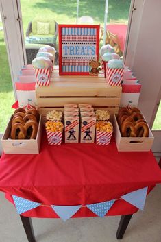 a red table topped with boxes filled with donuts