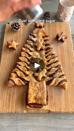 a wooden cutting board topped with pastry cut out to look like a christmas tree